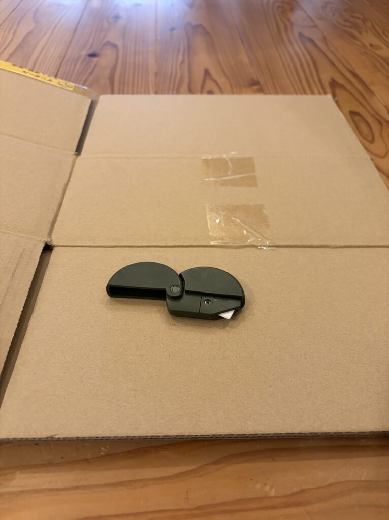 畳んだ段ボールと段ボールカッターの写真